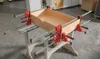 A wooden drawer is being clamped together on a workbench with several red and silver clamps. Produktbild-Vorschau