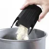 A hand is holding a black tool, pouring a light-colored powder into a silver metal bowl. Produktbild-Vorschau