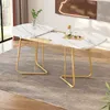 A marble-effect dining table with gold legs is shown in a room setting. Anteprima dell’immagine prodotto