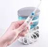 A hand holding a water flosser handle in front of its base unit. Produktbild-Vorschau