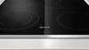 A close-up shot of a black induction hob with silver trim. Produktbild-Vorschau