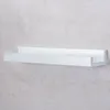 A white shelf mounted on a textured gray wall. Produktbild-Vorschau