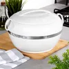 A white insulated thermos bowl with a silver band sits on a wooden cutting board, with a kitchen counter and stove in the background. Produktbild-Vorschau