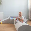 A young child plays on a soft play structure in a room. Produktbild-Vorschau