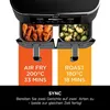 A close-up marketing image of a dual-basket air fryer, showing food in each basket and text describing cooking functions. Produktbild-Vorschau