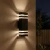 An outdoor wall light fixture is mounted on a textured wall at night. Produktbild-Vorschau