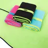 Three folded microfiber towels on a larger unfolded towel. Produktbild-Vorschau