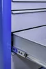 A close-up view of an open drawer in a blue cabinet, showing the metal drawer slides. Produktbild-Vorschau
