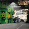 A person walks through a large industrial factory with heavy machinery and overhead lighting. Produktbild-Vorschau