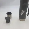 A black Stanley vacuum flask with its lid and a separate cup are placed on a white surface. Náhled obrázku produktu
