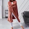 A person wearing a hooded blanket in a living room. Podgląd zdjęcia produktu