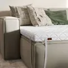 A mattress topper on a bed with pillows. Produktbild-Vorschau