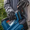 A person wearing gloves is inserting a battery into a blue leaf blower. Produktbild-Vorschau