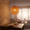 A dining table set for a meal with a pendant light hanging above, in a living room setting with a sofa and coffee table in the background. Náhled obrázku produktu