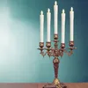A brass candelabra with five LED candles is displayed on a wooden surface against a teal background. Anteprima dell’immagine prodotto