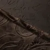 A close-up view of a brown velvet curtain with a floral pattern. Produktbild-Vorschau
