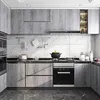 A modern kitchen with gray wood-effect cabinets and white marble-patterned backsplash. Náhľad obrázku produktu