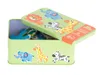 A light green tin box with a lid open, revealing puzzle pieces inside. The lid and the side of the box are decorated with cartoon safari animals. Náhled obrázku produktu