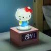 A Hello Kitty digital alarm clock with a night light function is displayed on a bedside table. Podgląd zdjęcia produktu
