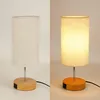 A split image showing a bedside lamp, with the left side unlit and the right side lit. Produktbild-Vorschau