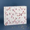 A white advent calendar box with red candy cane and snowflake designs and numbers is shown against a blue background. Produktbild-Vorschau