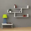 A modern white wall shelf unit with books and a plant, next to a lamp on a bench. Anteprima dell’immagine prodotto