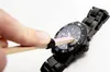A hand is using a tool with a pink tip to polish the glass of a black watch. Produktbild-Vorschau