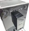 A close-up view of the control panel and dispensing spout of a black coffee machine. Produktbild-Vorschau
