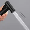 A hand holding a black bidet sprayer with water spraying out. Produktbild-Vorschau