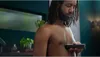 A man is trimming his chest hair in a bathroom. Produktbild-Vorschau