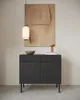 A dark wood sideboard with two doors and two drawers, displayed in a minimalist setting with a pendant light and artwork. Produktbild-Vorschau