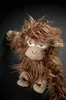 A stuffed monkey toy with shaggy brown fur and beige fabric face and paws, against a dark background. Náhled obrázku produktu