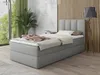 A bedroom scene with a bed, plant, and lamp.