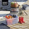 Storage boxes and fishing gear on a wooden dock by the water. Produktbild-Vorschau