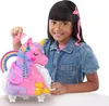 A young girl is playing with a pink unicorn toy that has colorful hair and accessories. Produktbild-Vorschau