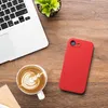 A red phone case, a laptop, and a cup of coffee are arranged on a wooden desk. Produktbild-Vorschau