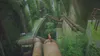 A cat is standing on a large pipe in a lush, overgrown, industrial environment with many pipes and greenery. Produktbild-Vorschau