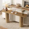 A console table with a lamp, books, and a coffee cup is placed behind a sofa in a living room with a fireplace. Produktbild-Vorschau