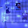 A grid display with photos and a vase, decorated with blue LED string lights. Produktbild-Vorschau