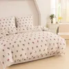 A neatly made bed with a floral patterned duvet cover and pillows. Anteprima dell’immagine prodotto