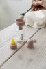 A hand is adding powder to a baby bottle using a funnel and spoon. Anteprima dell’immagine prodotto