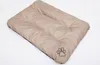 A beige dog mat with a paw print logo on a white background. Podgląd zdjęcia produktu
