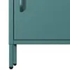 A close-up view of the bottom corner of a teal metal cabinet, showing its leg and a portion of the door. Anteprima dell’immagine prodotto