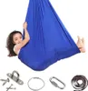 A young girl is inside a blue fabric swing, with various hardware accessories laid out below. Produktbild-Vorschau