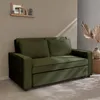 A green sofa in a room with a textured wall and decorative items. Anteprima dell’immagine prodotto