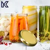 A collection of jars filled with preserved vegetables and a golden lid in the foreground. Voir les images du produit