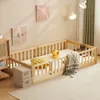 A child's wooden bed with safety rails and bedding in a room. Produktbild-Vorschau