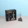Master Sword Metallpuzzle aus The Legend of Zelda mit Verpackung; Miniatur-Schwert im Sockel vor hellblauem Hintergrund Náhľad obrázku produktu