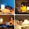 Collage of four scenes showing a bedside lamp in different settings: a couple sleeping, a woman working on a laptop, a woman watching TV, and a child sleeping. Produktbild-Vorschau