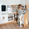 A young child is playing with a wooden toy kitchen. Podgląd zdjęcia produktu